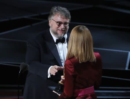 90th Academy Awards - Oscars Show - Hollywood, California, U.S., 04/03/2018 - Guillermo del Toro accepts the Oscar for Best Director for "The Shape of Water" from presenter Emma Stone (R). REUTERS/Lucas Jackson