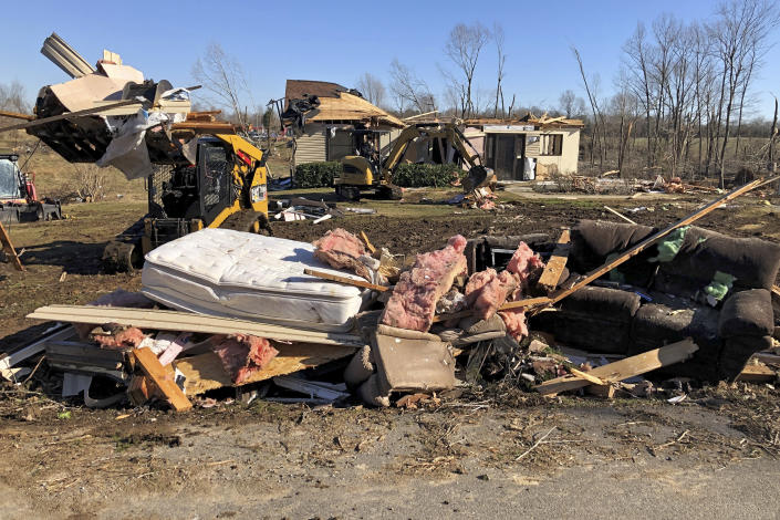 Workers operating heavy equipment remove debris as they demolish a home that was heavily damaged by a tornado on Jan. 11, 2022, in Benton. Ky. The town was one of several struck by a tornado in December. (AP Photo/Adrian Sainz)