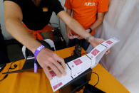 ** HOLD FOR STORY ** In this photo taken Friday, June 21, 2019, FlipTix workers load a ticket printer in their tent at the entrance to the Clusterfest comedy event in San Francisco. The company's application lets people who leave a venue early sell their ticket and lets someone who wants the remainder of the ticket buy it. (AP Photo/Eric Risberg)