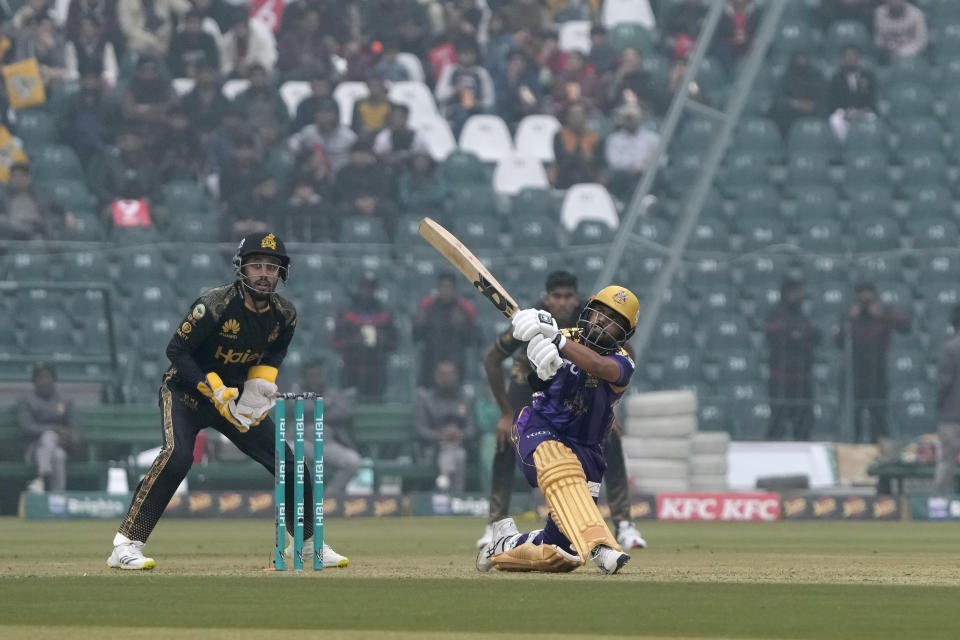 Quetta Gladiators' Saud Shakeel, right, plays a shot for six as Peshawar Zalmi' Mohammad Haris watches during the Pakistan Super League T20 cricket match between Quetta Gladiators and Peshawar Zalmi, in Lahore, Pakistan Sunday, Feb. 18, 2024. (AP Photo/K.M. Chaudary)