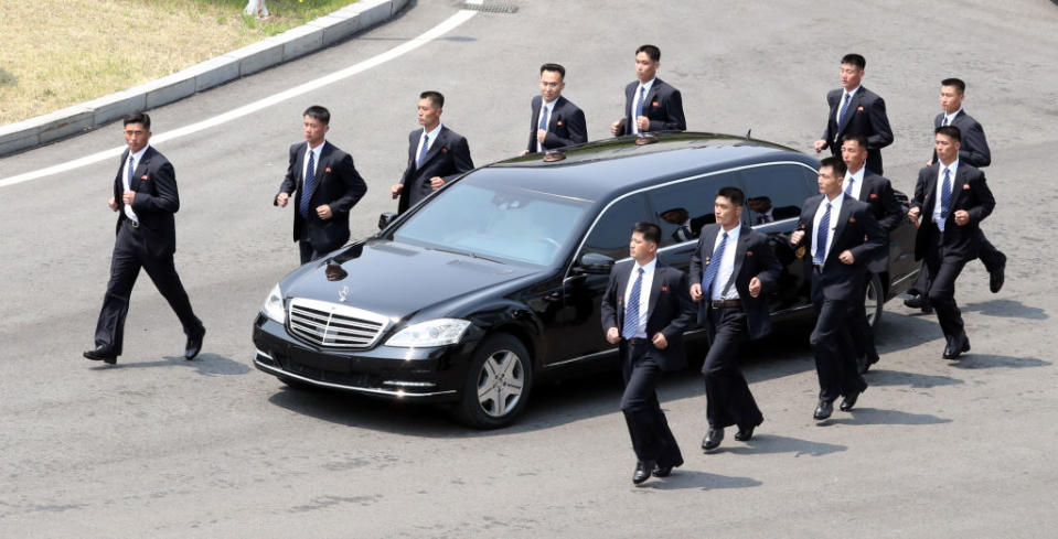 Kim Jong-un’s bodyguards surround his limousine during a summit in April between North and South Korea (Picture: Getty)