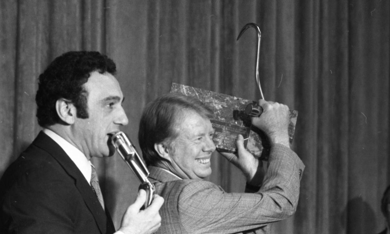 Democratic presidential candidate Jimmy Carter holds up a longshoreman's hook and plaque that he received at a rally on Oct. 29, 1976, in Brooklyn, from the longshoremen's union boss Anthony Scotto. Later in the day, the candidate spoke Hofstra University in Long Island.