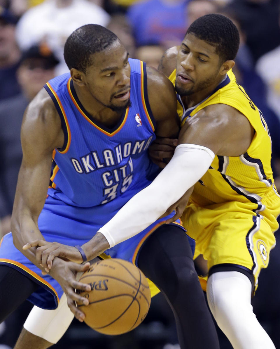 Indiana Pacers forward Paul George, right, attempts to knock the ball away from Oklahoma City Thunder forward Kevin Durant in the second half of an NBA basketball game in Indianapolis, Sunday, April 13, 2014. The Pacers defeated the Thunder 102-97. (AP Photo/Michael Conroy)