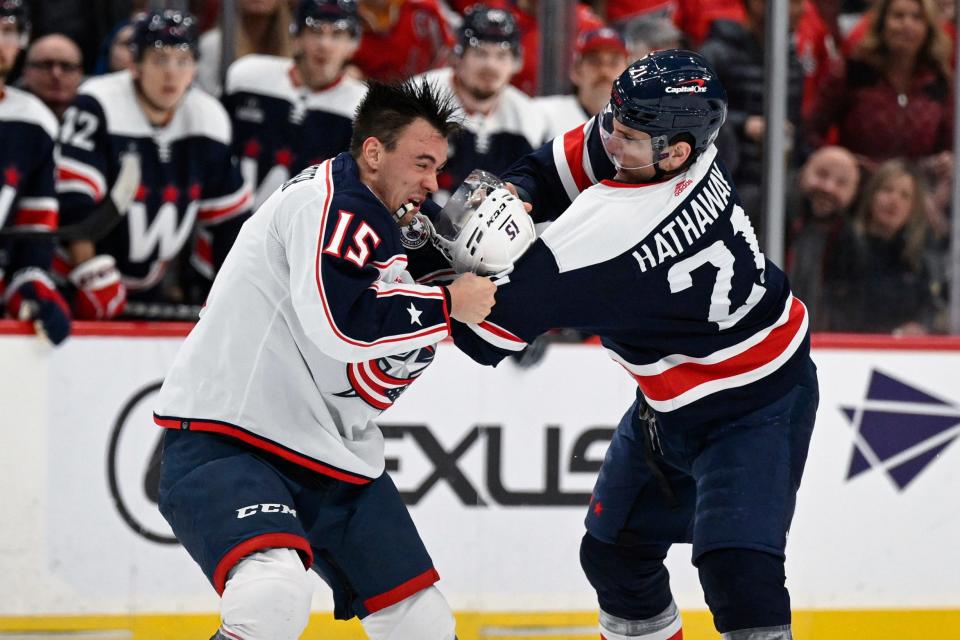 Columbus Blue Jackets defenseman Gavin Bayreuther (15) and Washington Capitals right wing Garnet Hathaway (21) fight during the first period of an NHL hockey game, Sunday, Jan. 8, 2023, in Washington. (AP Photo/Terrance Williams)
