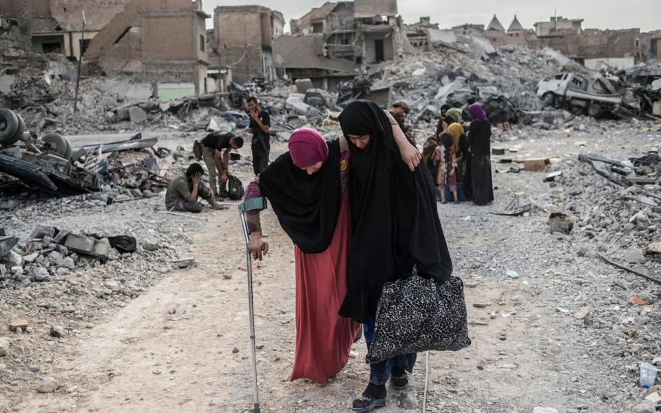 An injured Iraqi woman arrives at an Iraqi forces checkpoint in the occupied Old City district where heavy fighting continues on July 8, 2017 - Credit: Getty