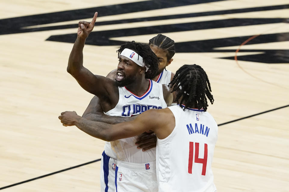 Los Angeles Clippers guard Patrick Beverley, middle, gestures toward fans while celebrating with Paul George, rear, and Terance Mann (14) during the second half of Game 2 of the NBA basketball Western Conference Finals against the Phoenix Suns, Tuesday, June 22, 2021, in Phoenix. (AP Photo/Matt York)