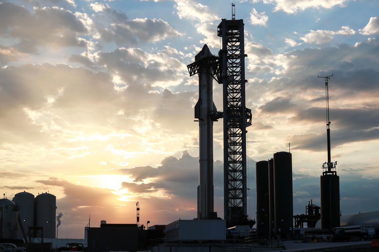 The orbital class Starship prototype stands fully stacked against the sunrise on Boca Chica Beach