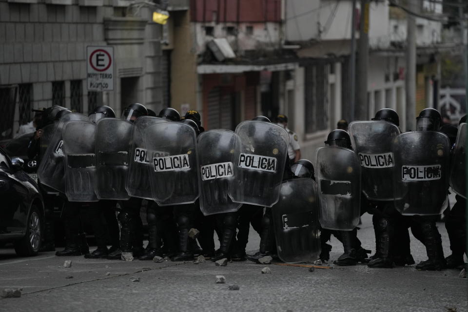 Riot police form a cordon against a group of veterans demanding that a law be passed that compensates them for having served during the country's civil war, outside the Congress building in Guatemala City, Tuesday, Oct. 19, 2021. (AP Photo/Moises Castillo)