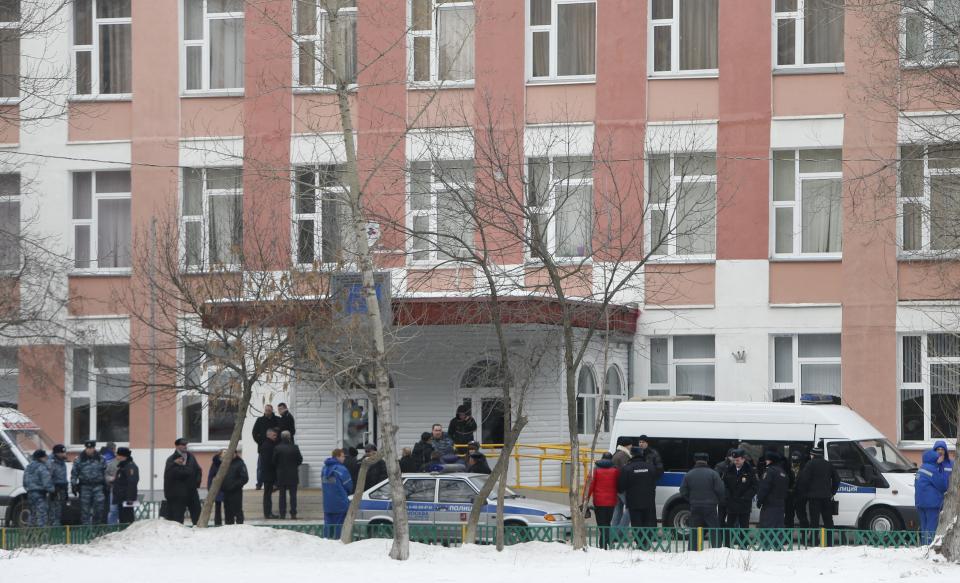 Interior Ministry members in uniform and other authorities gather outside a high school, where a student shot a teacher and a police officer dead and held more than 20 other students hostage, on the outskirts of Moscow