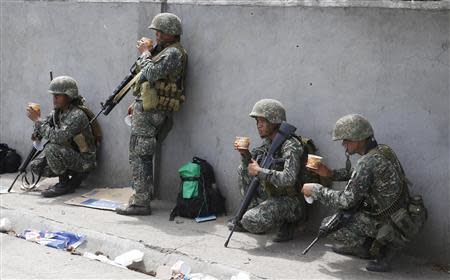 Members of Philippine Marines eat a meal at their positions on the fourth day of a government stand-off with the Moro National Liberation Front (MNLF) rebels in downtown Zamboanga city in southern Philippines September 12, 2013. REUTERS/Erik De Castro