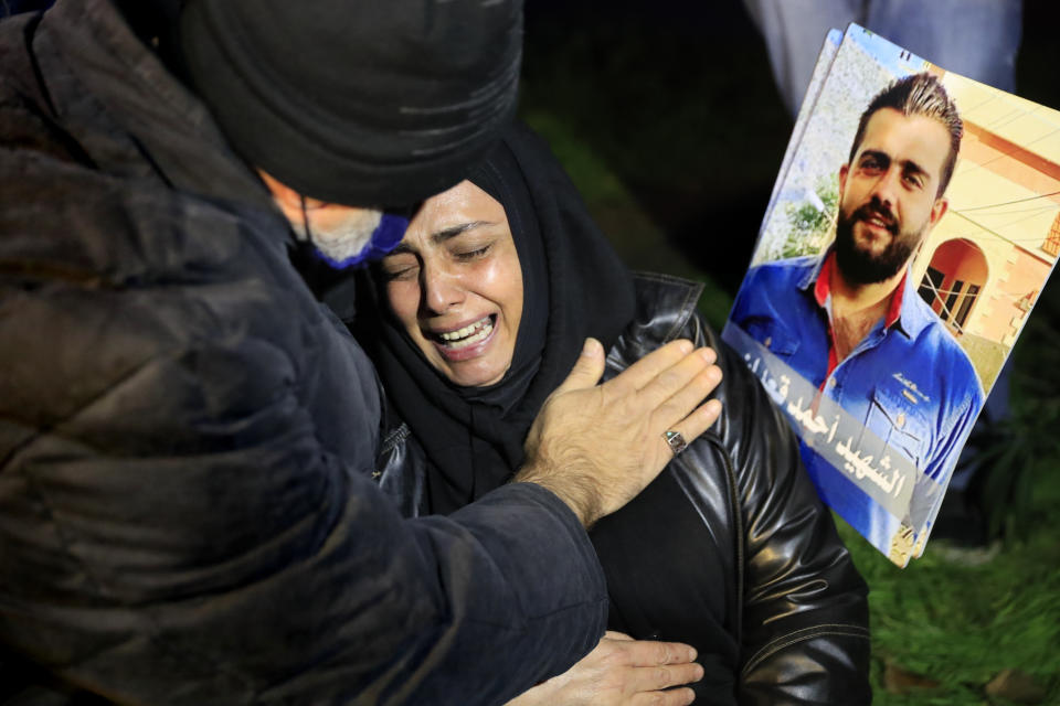 A mother of a victim of the Aug. 4, 2020 Beirut port explosion reacts next of a portrait of her son who killed during the explosion, during a sit-in outside the Justice Palace, in Beirut, Lebanon, Thursday, Feb. 18, 2021. Lebanon's highest court asked the chief prosecutor investigating last year's massive Beirut port explosion to step down, following legal challenges by senior officials he had accused of negligence that led to the blast, a judicial official and the country's official news agency said. (AP Photo/Hussein Malla)