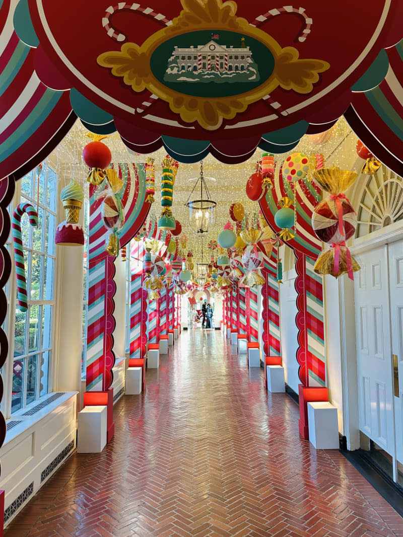 candy cane lined long hallway with white house seal in red banner