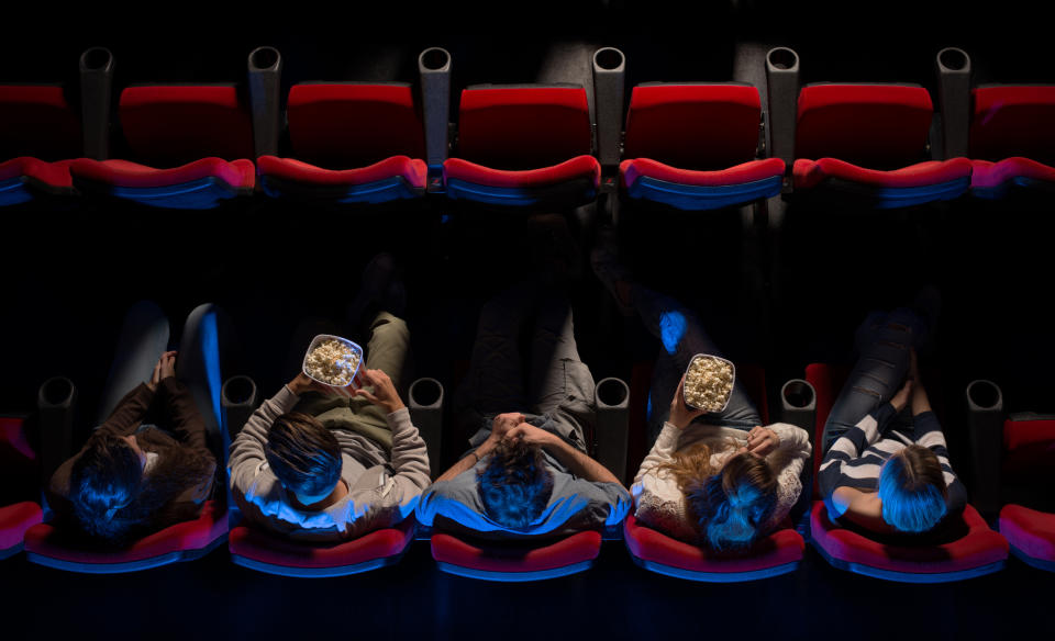 Overhead view of people eating popcorn in movie-theater seats