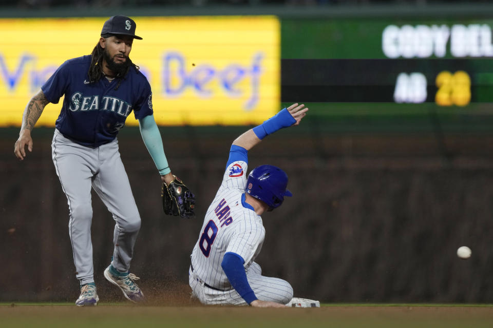 Chicago Cubs' Ian Happ, right, steals second base as Seattle Mariners shortstop J.P. Crawford, left, misses a catch during the fourth inning of a baseball game in Chicago, Monday, April 10, 2023. (AP Photo/Nam Y. Huh)