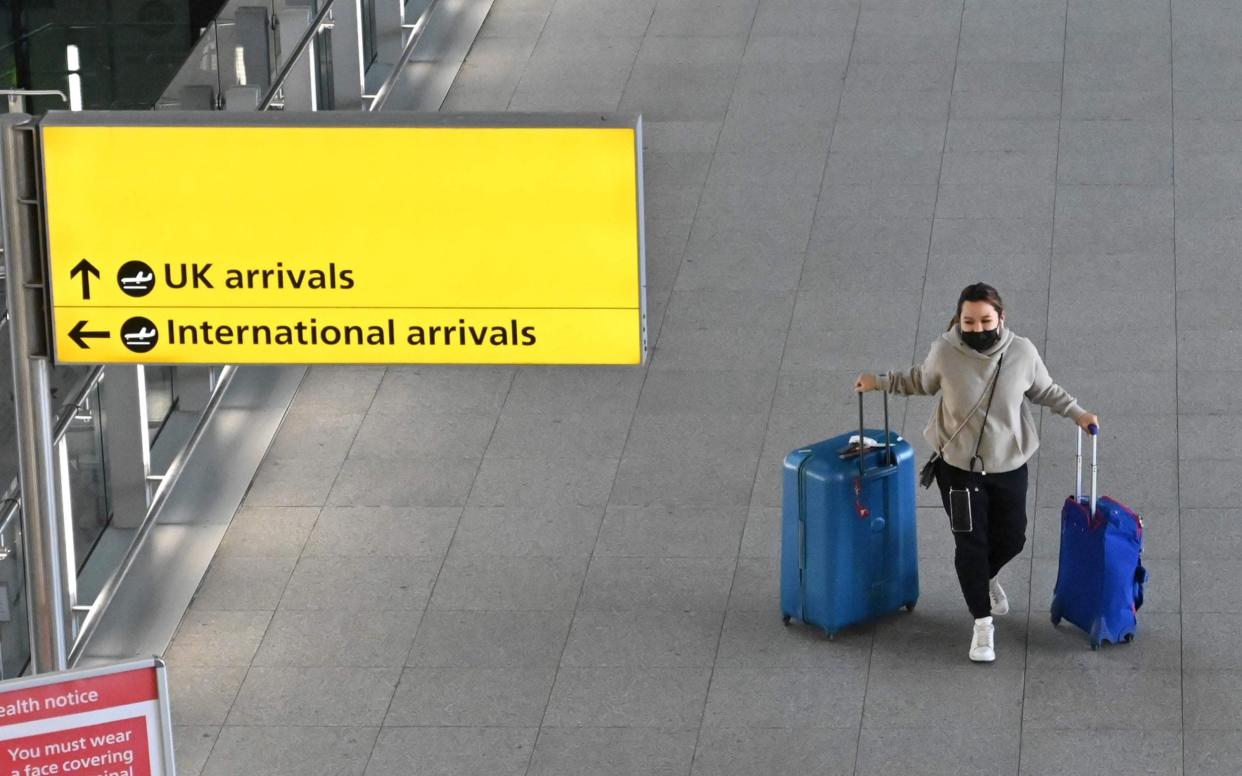 A passenger with luggage is seen at London Heathrow Airport in west London - JUSTIN TALLIS/AFP