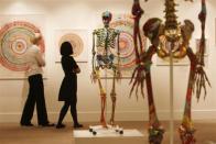 Visitors walk through a gallery containing works by Damien Hirst, collectively entitled 'Beautiful Inside My Head Forever,' at Sotheby's in London on September 8, 2008.