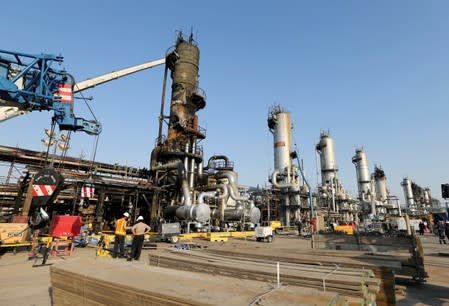 Workers are seen at the damaged site of Saudi Aramco oil facility in Abqaiq