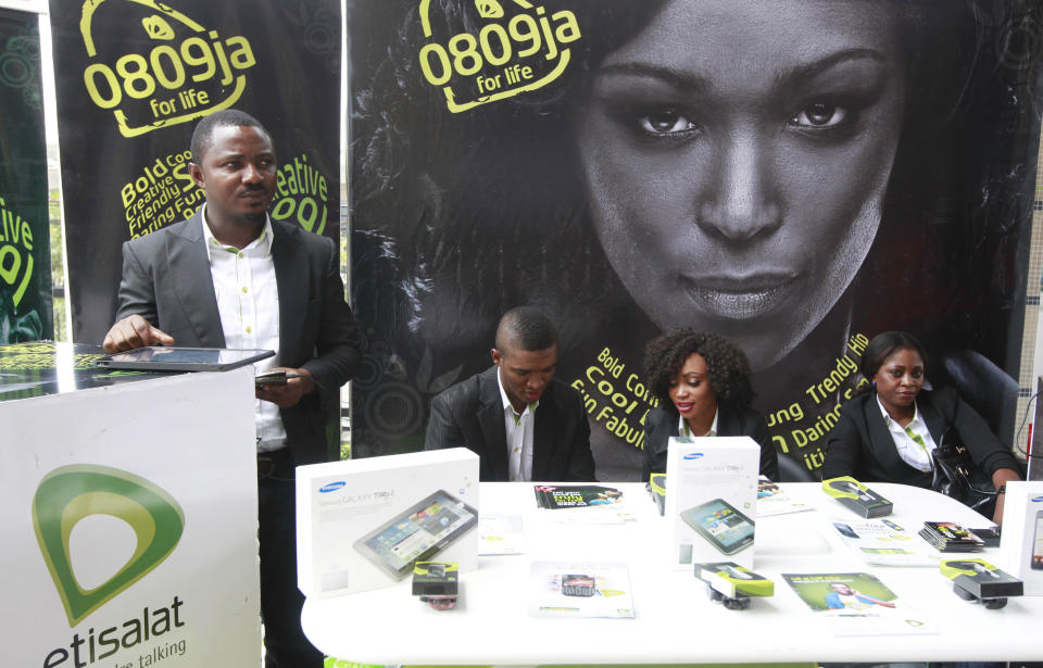 FILE - In this Monday, April. 22, 2013 file photo, Staff of Etisalat Nigeria wait for customers during the launch of mobile number portability in Lagos, Nigeria. Nigeria is set to overtake South Africa as the biggest economy in Africa with a long-overdue recount of its GDP that will give it continental bragging rights but do little for its 112 million people scrabbling to survive in desperate poverty. That’s cause for reflection in longtime rival South Africa, the only African member of the G20, on the strength of its position as the continent’s economic powerhouse. Finance Minister Ngozi Ikonjo-Iweala is to announce new GDP figures on Sunday, April. 6, 2014 to include previously uncounted industries like telecommunications and IT, banking and insurance, music and airlines, and the burgeoning online retail outlets and Nollywood films that didn’t exist when the last count was made in 1990. Then, there were 300,000 landlines. Today, Nigeria has 100 million cell phone users. (AP Photo/ Sunday Alamba File)