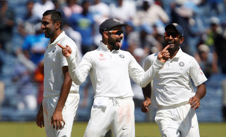 Cricket - India v Australia - First Test cricket match - Maharashtra Cricket Association Stadium, Pune, India - 23/02/17. India's captain Virat Kohli celebrates the wicket of Australia's captain Steve Smith with teammates Ravichandran Ashwin and Jayant Yadav. REUTERS/Danish Siddiqui