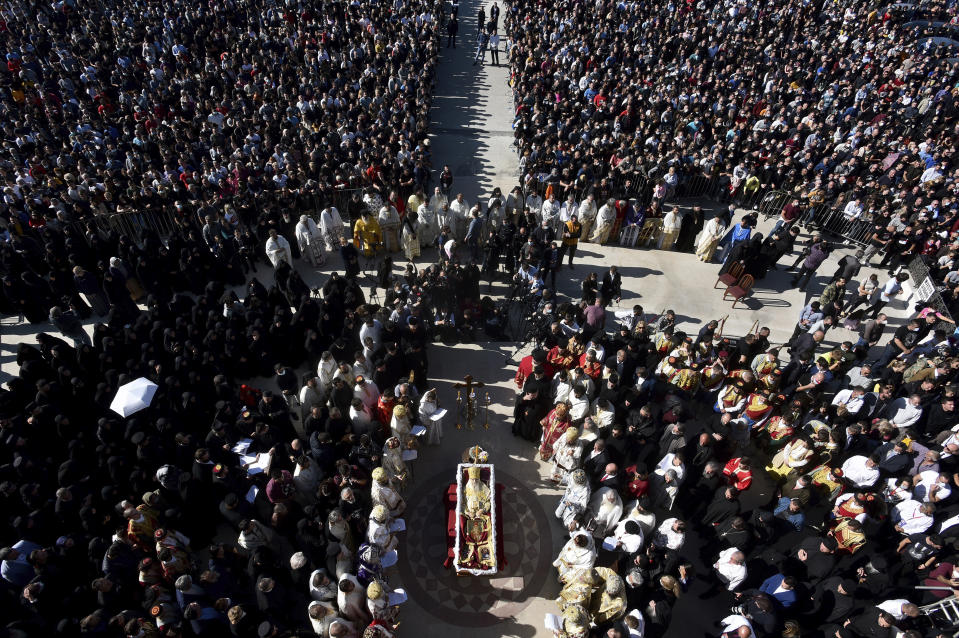 Thousands gathered by an open casket with Bishop Amfilohije's body during the liturgy and and funeral outside the main temple in the capital Podgorica, Montenegro, Sunday, Nov. 1, 2020. Bishop Amfilohije died on Friday after contracting the coronavirus weeks ago. A mass funeral on Sunday was held for the popular head of the Serbian Orthodox Church in Montenegro in violation of restrictions that are in place against the new coronavirus. (AP Photo/Risto Bozovic)