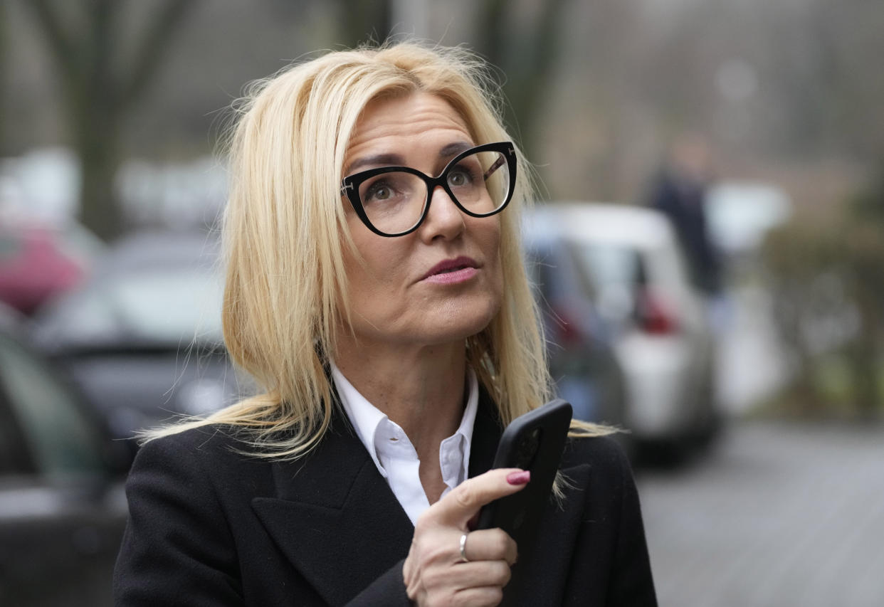 Ewa Wrzosek, a Polish prosecutor, stands outside her office holding her phone, in Warsaw, Poland, on Thursday, Dec. 16, 2021. Wrzosek, a prosecutor who is resisting a political takeover of the system of state prosecution, and an erosion of judicial independence more broadly under Poland's right-wing populist government, was the target of cellphone eavesdropping this year. She and a prominent Polish lawyer have become the first two confirmed cases involving the use of Pegasus military grade spyware against targets in Poland, where an illiberal government is eroding democratic norms. (AP Photo/Czarek Sokolowski)