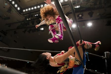 Wrestler Kairi Hojo jumps at her opponent Mieko satomura during their Stardom female professional wrestling show at Korakuen Hall in Tokyo, Japan, July 26, 2015. REUTERS/Thomas Peter/Files