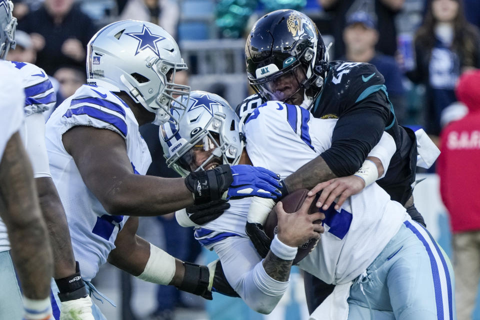Jacksonville Jaguars defensive end Arden Key (49) sacks Dallas Cowboys quarterback Dak Prescott (4) during the second half of an NFL football game, Sunday, Dec. 18, 2022, in Jacksonville, Fla. (AP Photo/John Raoux)