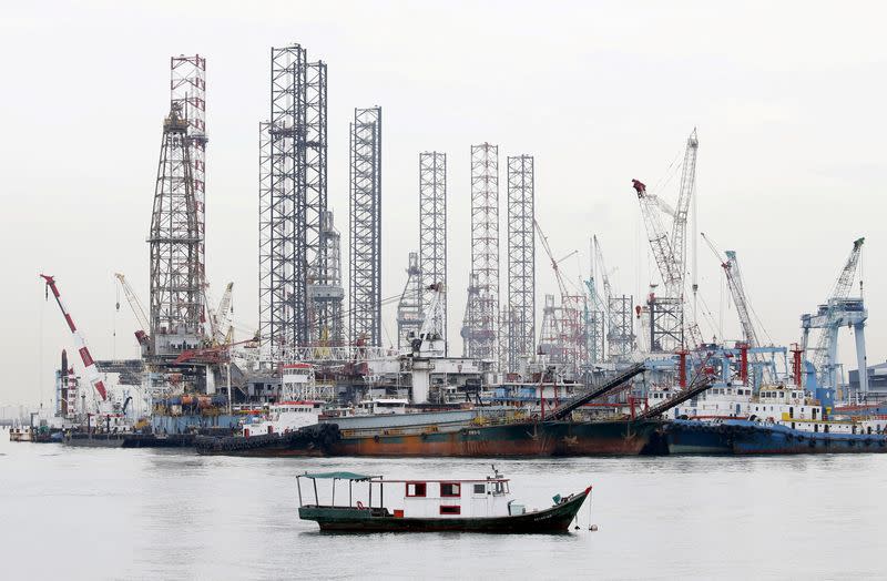 FILE PHOTO: Offshore drilling platforms (rear) stand together at a dock yard near Singapore port