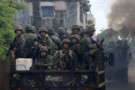 Soldiers onboard military trucks ride along the main street as government troops continue their assault on insurgents from the Maute group, who have taken over large parts of Marawi City, Philippines. REUTERS/Romeo Ranoco