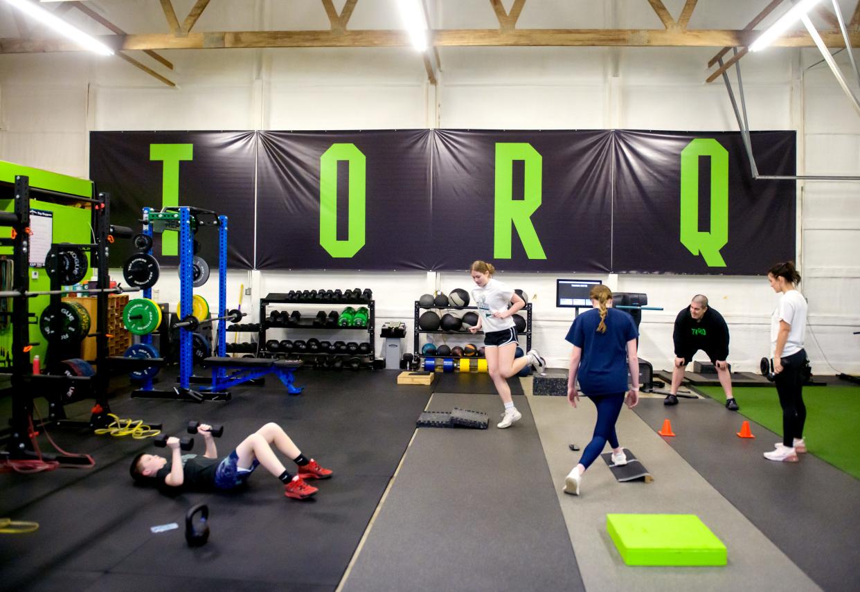 A group of young athletes work out at the Torq Fitness & Performance facility in East Peoria under the supervision of owner and trainer Kyle Piraino.