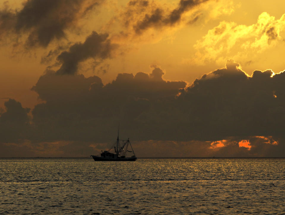 FILE - In this May 20, 2010 file photo, a shrimp boat carrying oil collection booms anchors for the night in Gulf of Mexico off the Mississippi River delta south of Venice, La. It will be months before state officials know whether losses from floods and spillway openings qualify Louisiana as a fisheries disaster. Department of Wildlife and Fisheries officials say floods began around November 2018, and a full 12 months' data is needed to compare to averages for the previous 5 years. The governors of Louisiana, Mississippi and Alabama asked months ago for US Commerce Secretary Wilbur Ross to declare a fisheries disaster, making federal grants available to affected people. (AP Photo/Charlie Riedel, File)