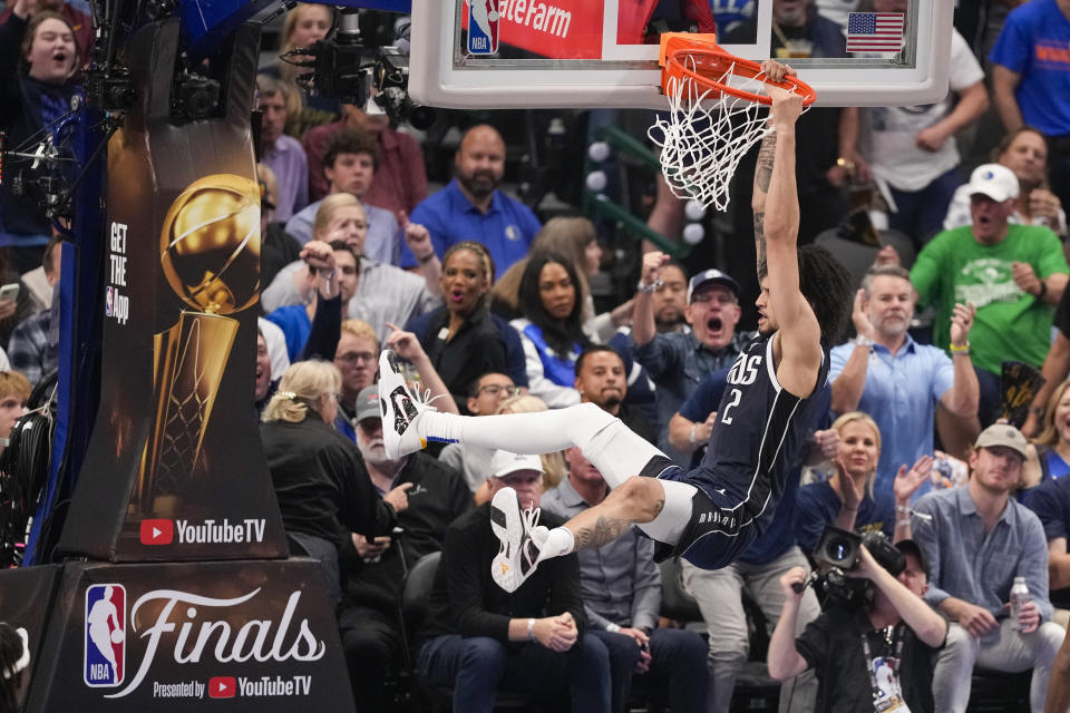 Dallas Mavericks center Dereck Lively II hangs from the rim after a basket against the Boston Celtics during the first half in Game 3 of the NBA basketball finals, Wednesday, June 12, 2024, in Dallas. (AP Photo/Sam Hodde)