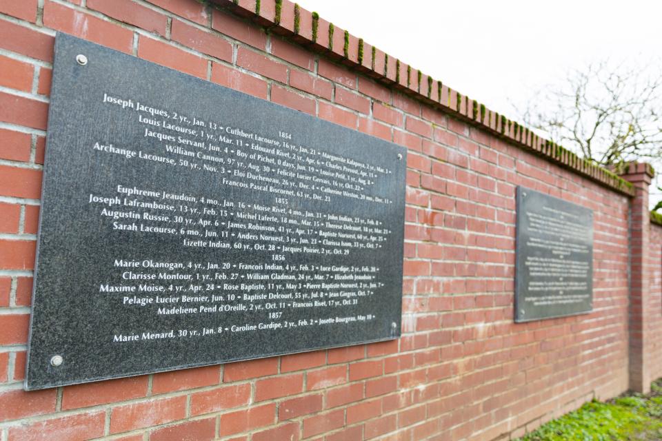 Plaques on the brick wall at St. Paul Pioneer Cemetery on Dec. 7 list the names and death dates of more than 500 early pioneers and Native Americans buried there, including William Cannon.
