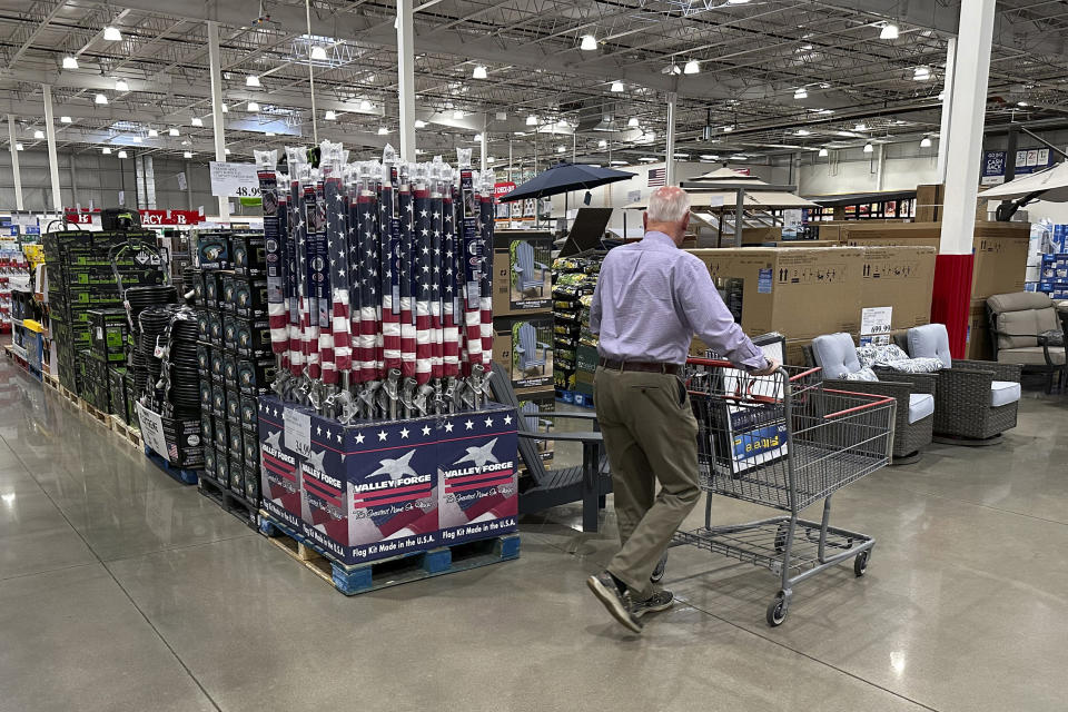 FILE - A shopper moves past a display of American flags in a Costco warehouse on May 18, 2024, in Sheridan, Colo. Costco said it would be closed on July 4th, 2024, but the vast majority of major national retailers will be open, with some offering promotional sales to lure customers. (AP Photo/David Zalubowski, File)