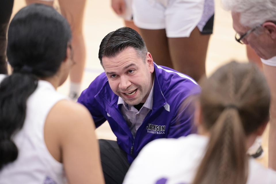 Jackson girls basketball coach Anthony Butch talks his team during a timeout against Hudson in a I district semifinal at Ravenna High School, Feb. 21, 2023.