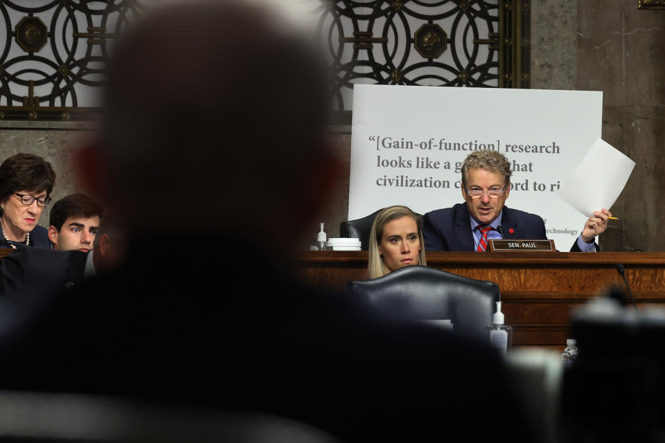 Sen. Rand Paul, holding a document, Dr. Anthony Fauci during a Senate committee hearing.