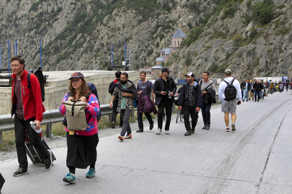 People, most of them Russians, cross the border between Georgia and Russia at Verkhny Lars, in Georgia, Wednesday, Sept. 28, 2022. The Kremlin's announcement of a partial mobilization in September sent waves of panic throughout the country. Flights abroad sold out and long lines formed at border crossings. Estimates say the number of those who left the country out of fear of being drafted into the army is in the hundreds of thousands. (AP Photo/Shakh Aivazov, File)