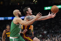 Atlanta Hawks guard Garrison Mathews (25) loses control of the ball as he drives against Boston Celtics guard Derrick White (9) during the first half of an NBA basketball game Thursday, March 28, 2024, in Atlanta. (AP Photo/John Bazemore)