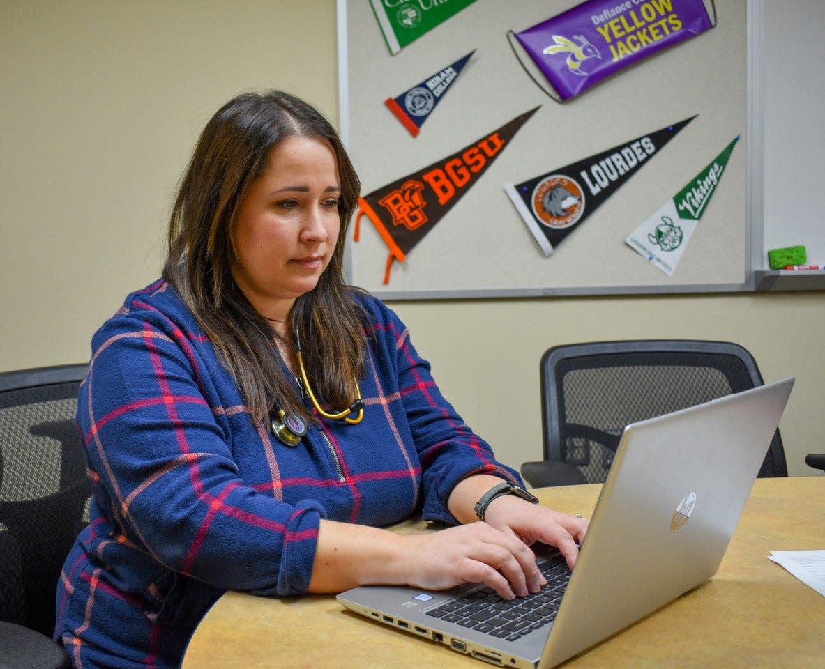 NOMS pediatric nurse practitioner Hillary Adams works on her laptop after seeing an ill student at McPherson Middle School on Jan. 18. Adams visits each school in the district once a month.