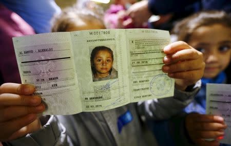 Four-year-old Syrian girl Maroa from the eastern Syrian town of Deir ez-Zor presents her newly issued "Ankunftsnachweis", an initial German registration document for migrants, following her family's registration at the former British Harewood barracks in Herford, western Germany February 22, 2016. REUTERS/Wolfgang Rattay