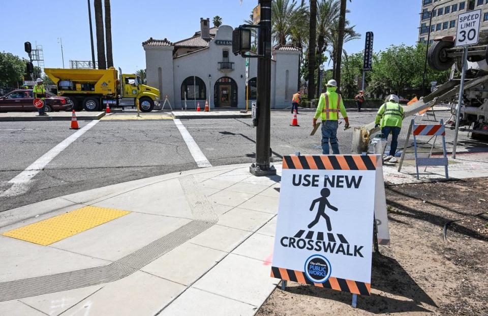 A sign points pedestrians to a new crosswalk near the Tulare Street Amtrak station and tracks at Tulare and R streets in downtown Fresno where construction is close to wrapping up on Monday, May 20, 2024. The crossing is at the center of a jaywalking incident that turned into a nightmare for a Fresno police officer.