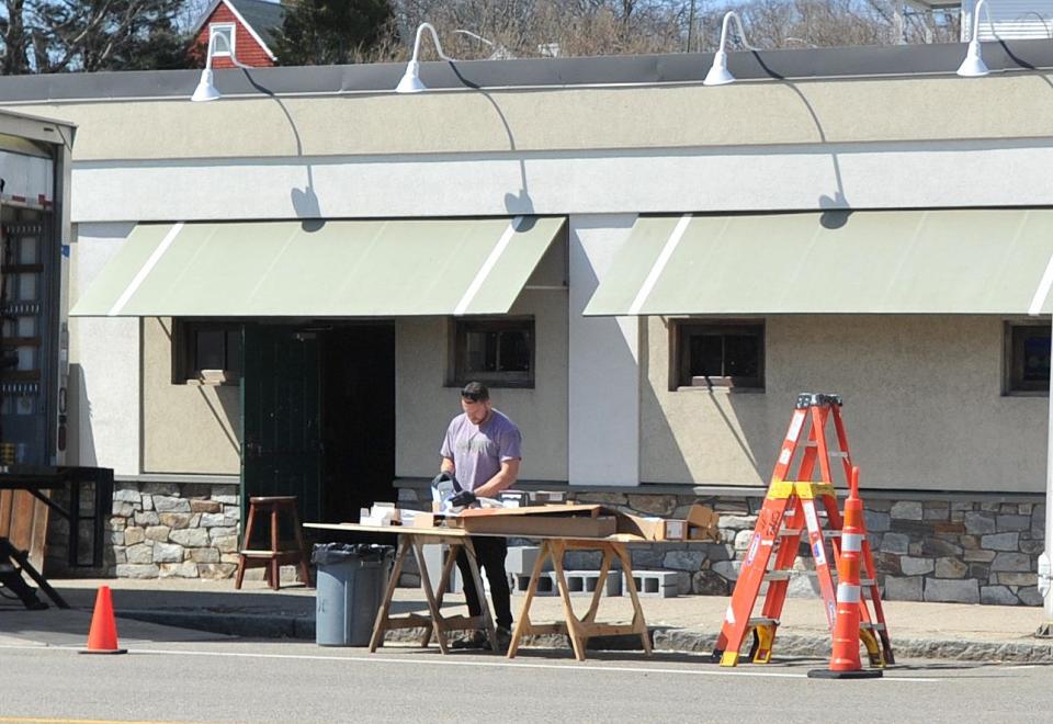 A film crew member prepares a set on Monday outside Malachy's Saloon on Granite Street in Quincy where scenes for the Casey Affleck and Matt Damon movie "The Instigators" will be filmed.