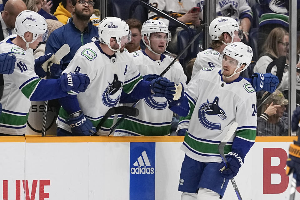 Vancouver Canucks center Pius Suter (24) celebrates a goal with teammates during the second period of an NHL hockey game against the Nashville Predators, Tuesday, Dec. 19, 2023, in Nashville, Tenn. (AP Photo/George Walker IV)