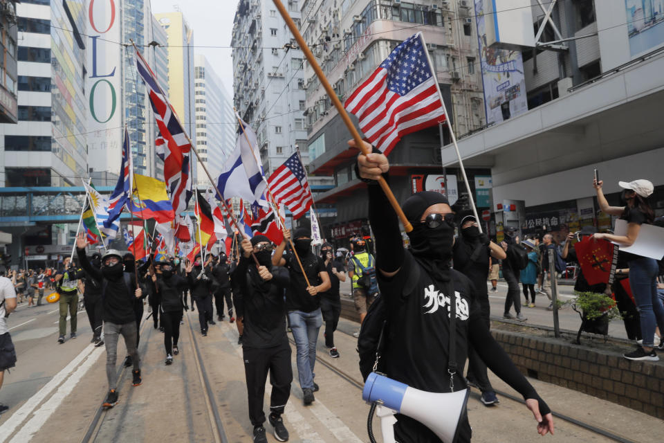 Protesters march with flags from various countries in Hong Kong on Sunday, Sept. 29, 2019. Sunday's gathering of protesters, a continuation of monthslong protests for greater democracy, is part of global "anti-totalitarianism" rallies planned in over 60 cities worldwide to denounce "Chinese tyranny." (AP Photo/Kin Cheung)