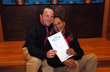 Darren Black Bear (R) and Jason Pickel (L) pose with their marriage license after they were married by Darren's father Rev. Floyd Black Bear in El Reno, Oklahoma October 31, 2013. REUTERS/Rick Wilking