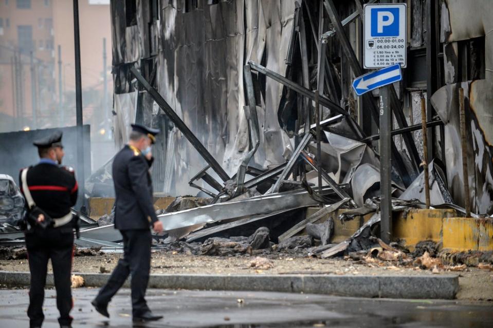 Carabinieri officers stand on the site of a plane crash, in San Donato (AP)