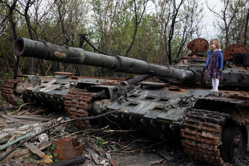 Un enfant se tient sur un char russe détruit, au milieu de l'invasion de l'Ukraine par la Russie, près de Makariv, région de Kiev, Ukraine le 7 mai 2022. REUTERS/Mikhail Palinchak