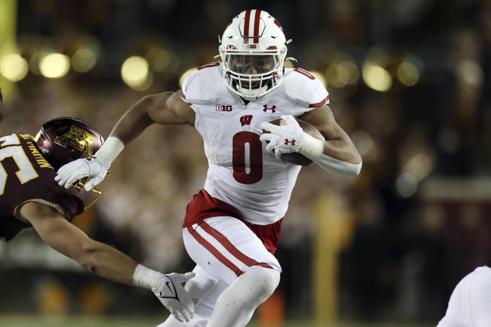 FILE - Wisconsin running back Braelon Allen (0) carries the ball during the second half of an NCAA college football game against Minnesota, Saturday, Nov. 27, 2021, in Minneapolis. Braelon Allen believes he can team up with Chez Mellusi and Isaac Guerendo to give the Badgers’ their best running-back trio in the program’s history. (AP Photo/Stacy Bengs, File)