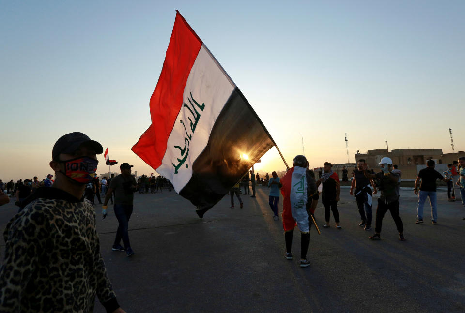 People walk through Khilani Square after protesters took control and reopened it after clashes between Iraqi security forces and anti-government demonstrators in Baghdad, Iraq, Saturday, Nov. 16, 2019. (AP Photo/Hadi Mizban)