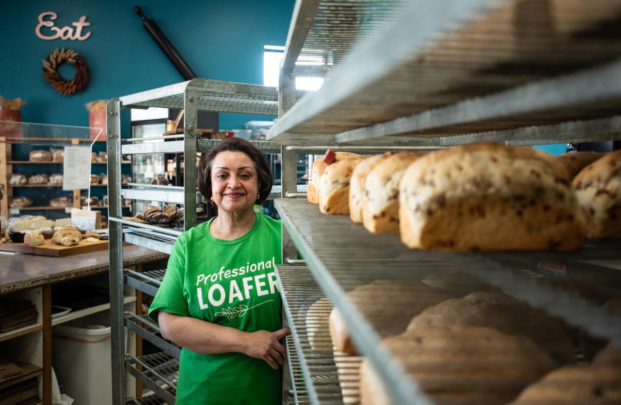 Great Harvest Bread Co. owner Alka Josh takes a picture with some of her freshly baked loaves of bread Thursday, April 25, 2024, at her store in Delta Township.